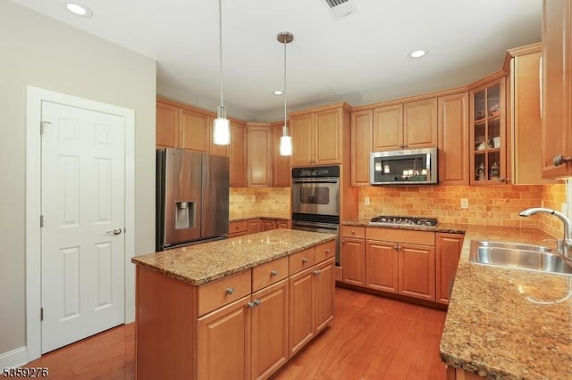 37 Hancock Pl, Franklin Twp, NJ 08873 - kitchen featuring stainless steel appliances, a sink, light wood finished floors, a center island, and decorative backsplash