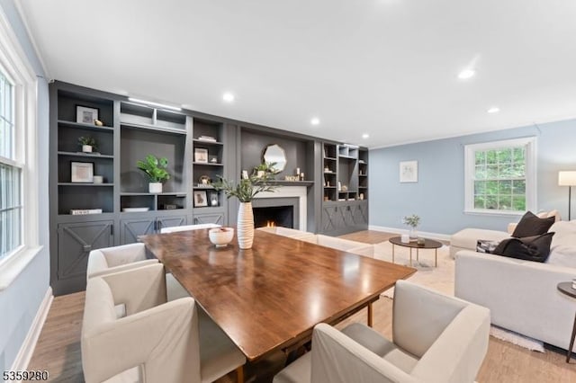 359 Dogwood Way, Mountainside Boro, NJ 07092 - dining area featuring a warm lit fireplace, baseboards, light wood-type flooring, recessed lighting, and built in features