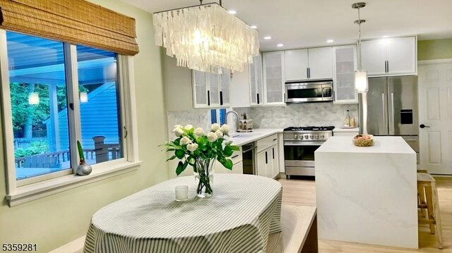 7 Park Dr, Kenilworth Boro, NJ 07033 - kitchen featuring appliances with stainless steel finishes, a sink, decorative backsplash, a chandelier, and a center island