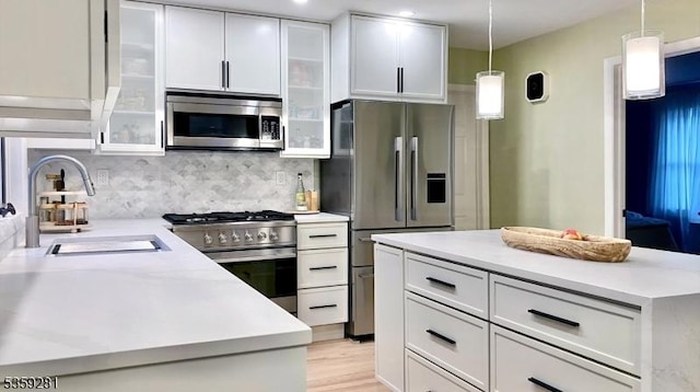 7 Park Dr, Kenilworth Boro, NJ 07033 - kitchen featuring stainless steel appliances, a sink, white cabinetry, tasteful backsplash, and hanging light fixtures