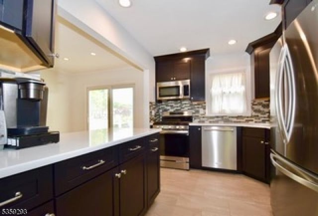 99 Mapes Ave, Springfield Twp, NJ 07081 - kitchen featuring stainless steel appliances, healthy amount of natural light, light countertops, decorative backsplash, and recessed lighting