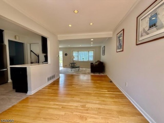 99 Mapes Ave, Springfield Twp, NJ 07081 - corridor with light wood-style flooring, crown molding, stairs, and recessed lighting