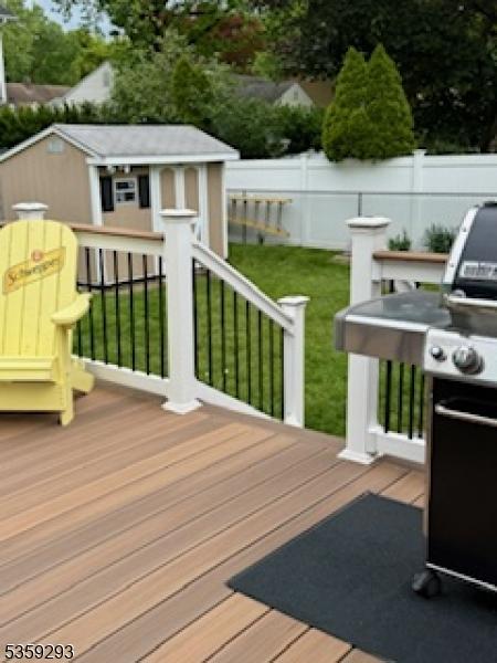 99 Mapes Ave, Springfield Twp, NJ 07081 - wooden deck with a fenced backyard, an outdoor structure, and area for grilling