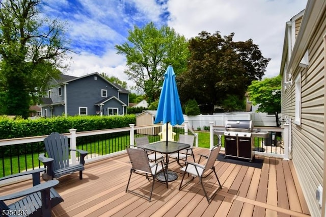 99 Mapes Ave, Springfield Twp, NJ 07081 - wooden terrace featuring outdoor dining space, a storage unit, a grill, and a fenced backyard