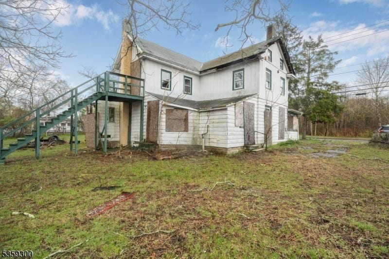611-615 S New York Rd, Galloway Twp, NJ 08205 - back of property with stairs, a chimney, a deck, and a lawn