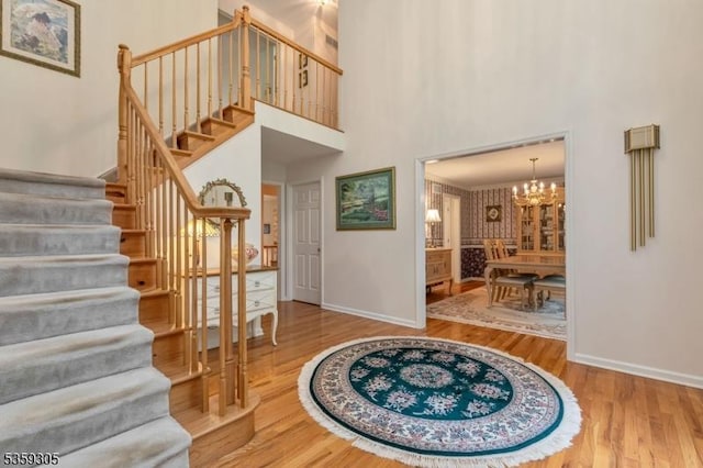 785 Backhus Estate Rd, Lebanon Twp, NJ 08826 - foyer entrance with a chandelier, stairs, wood finished floors, baseboards, and a high ceiling
