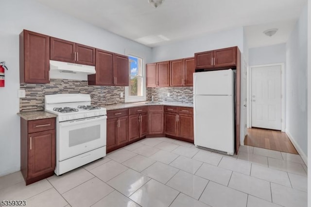 171 Sherman Ave, Newark City, NJ 07114 - kitchen with white appliances, under cabinet range hood, backsplash, light countertops, and a sink