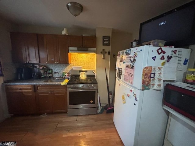 166 Fulton St, New Brunswick City, NJ 08901 - kitchen with stainless steel range with gas cooktop, freestanding refrigerator, light wood-style flooring, under cabinet range hood, and a sink