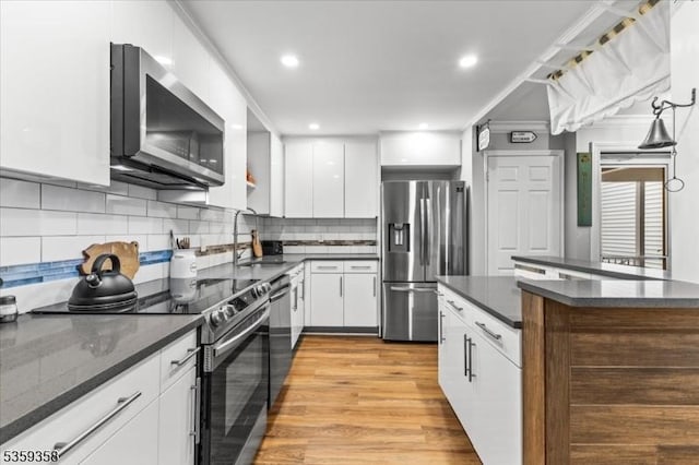 85 Smithfield Ct, Bernards Twp, NJ 07920 - kitchen featuring appliances with stainless steel finishes, white cabinets, a sink, decorative backsplash, and light wood-type flooring