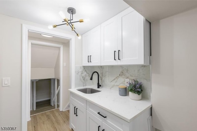 1190 Union St, Linden City, NJ 07036 - kitchen with a sink, a chandelier, decorative backsplash, white cabinetry, and light countertops