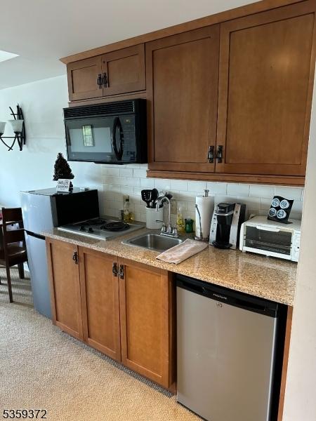 200 State Rt 94 Unit 259, Vernon Twp, NJ 07462 - kitchen with dishwashing machine, black microwave, a sink, tasteful backsplash, and light carpet