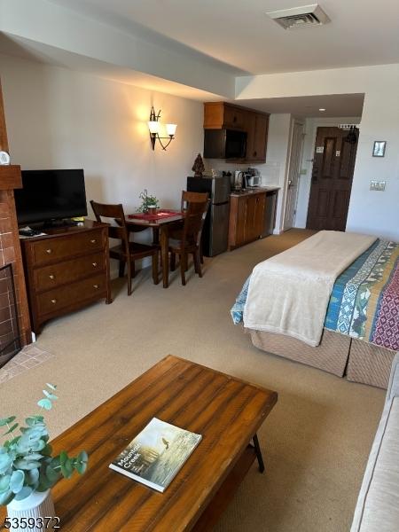 200 State Rt 94 Unit 259, Vernon Twp, NJ 07462 - bedroom with refrigerator, light colored carpet, and a fireplace with flush hearth