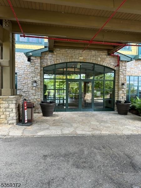 200 State Rt 94 Unit 259, Vernon Twp, NJ 07462 - view of exterior entry featuring stone siding and french doors