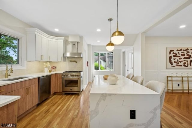371 Franklin Pl S, Orange Village Twp, NJ 07079 - kitchen featuring stainless steel appliances, healthy amount of natural light, light wood-style floors, wall chimney exhaust hood, and recessed lighting