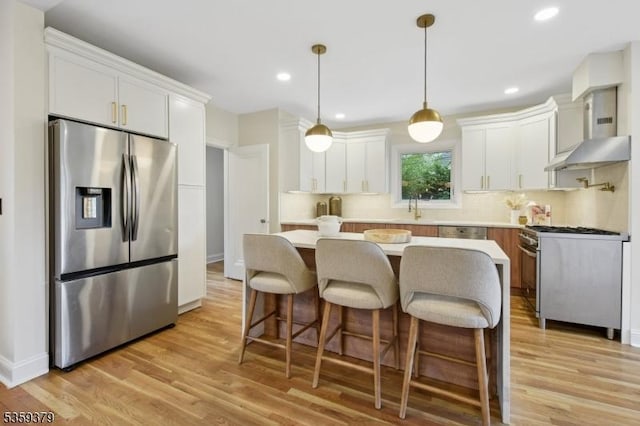 371 Franklin Pl S, Orange Village Twp, NJ 07079 - kitchen with stainless steel appliances, wall chimney range hood, a kitchen island, light wood-type flooring, and light countertops