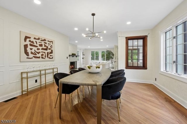 371 Franklin Pl S, Orange Village Twp, NJ 07079 - dining area featuring wood finished floors, a chandelier, a brick fireplace, and recessed lighting