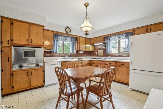 129 Severin Ct, Cranford Twp, NJ 07016 - kitchen featuring white appliances, light flooring, decorative backsplash, light countertops, and brown cabinetry