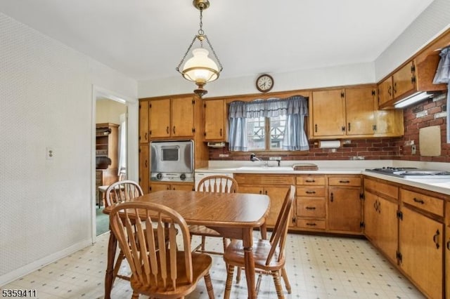 129 Severin Ct, Cranford Twp, NJ 07016 - kitchen with light floors, a sink, light countertops, brown cabinets, and pendant lighting