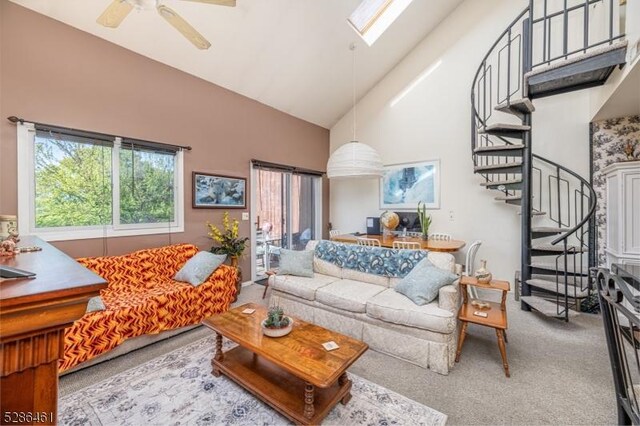 2 Sunrise Dr Unit 6, Vernon Twp, NJ 07462 - carpeted living room with stairway, high vaulted ceiling, a ceiling fan, and a skylight