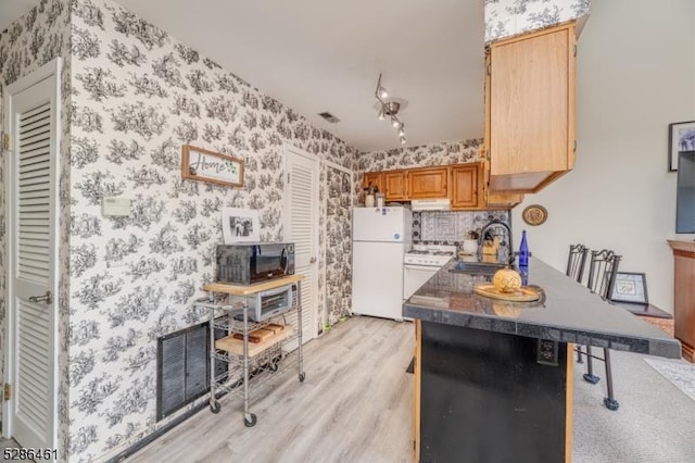 2 Sunrise Dr Unit 6, Vernon Twp, NJ 07462 - kitchen with white appliances, a sink, wallpapered walls, light wood-style floors, and under cabinet range hood