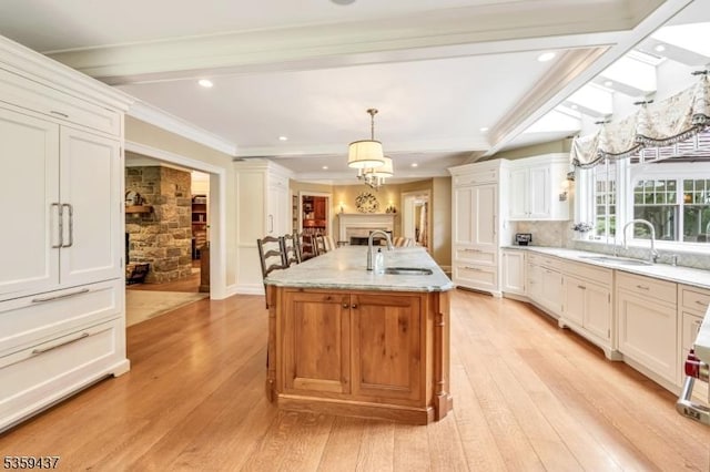 259 Indian Trail Dr, Franklin Lakes Boro, NJ 07417 - kitchen featuring a sink, light wood finished floors, a kitchen island with sink, ornamental molding, and beamed ceiling