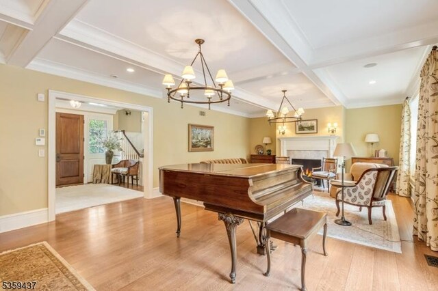 259 Indian Trail Dr, Franklin Lakes Boro, NJ 07417 - sitting room featuring coffered ceiling, light wood finished floors, beamed ceiling, a chandelier, and a lit fireplace