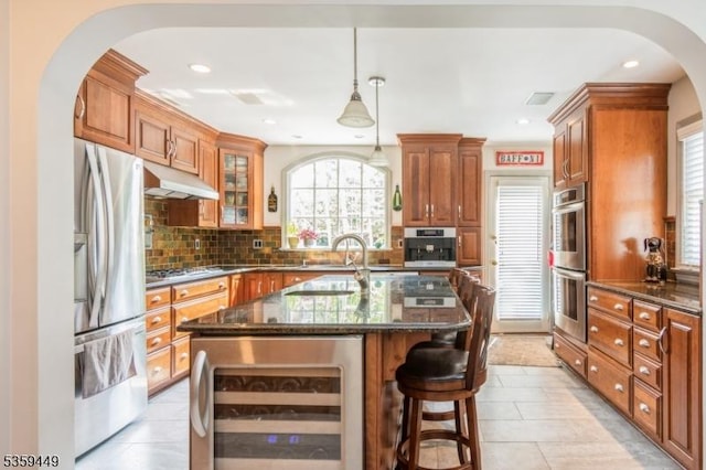 947 Madison Ave, Plainfield City, NJ 07060 - kitchen featuring wine cooler, arched walkways, stainless steel appliances, under cabinet range hood, and tasteful backsplash