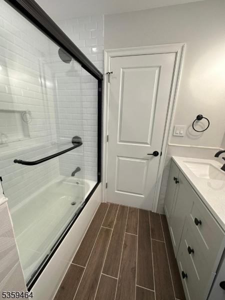 228 78th St, North Bergen Twp, NJ 07047 - full bathroom with wood finish floors, shower / bath combination with glass door, and vanity