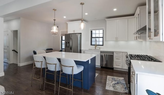 228 78th St, North Bergen Twp, NJ 07047 - kitchen featuring stainless steel appliances, a chandelier, wall chimney range hood, a kitchen island, and white cabinets