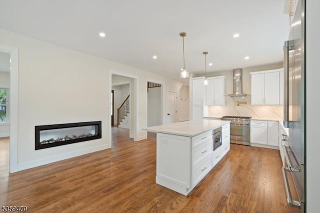 1 Willow Pl, East Hanover Twp, NJ 07936 - kitchen with wall chimney range hood, high quality appliances, a kitchen island, white cabinets, and wood finished floors