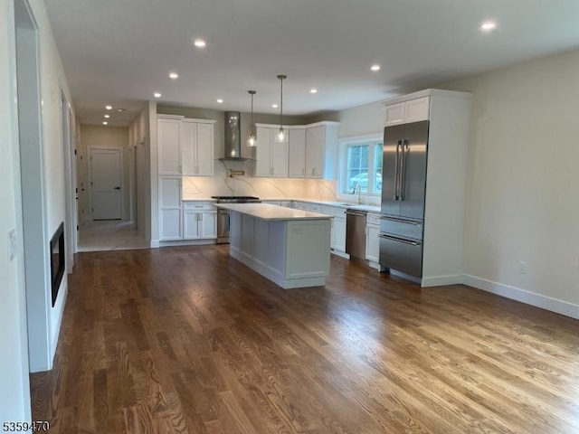 1 Willow Pl, East Hanover Twp, NJ 07936 - kitchen featuring appliances with stainless steel finishes, wall chimney range hood, a kitchen island, light countertops, and white cabinets