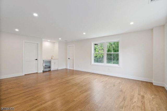 1 Willow Pl, East Hanover Twp, NJ 07936 - unfurnished living room featuring wine cooler, bar, light wood-style flooring, recessed lighting, and baseboards
