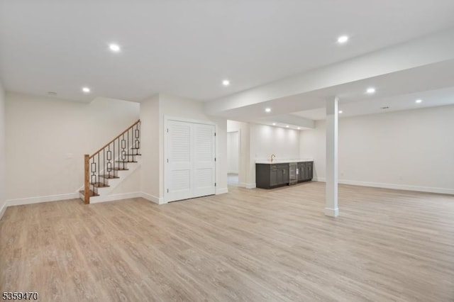 1 Willow Pl, East Hanover Twp, NJ 07936 - finished below grade area with bar with sink, stairs, light wood-style flooring, recessed lighting, and baseboards