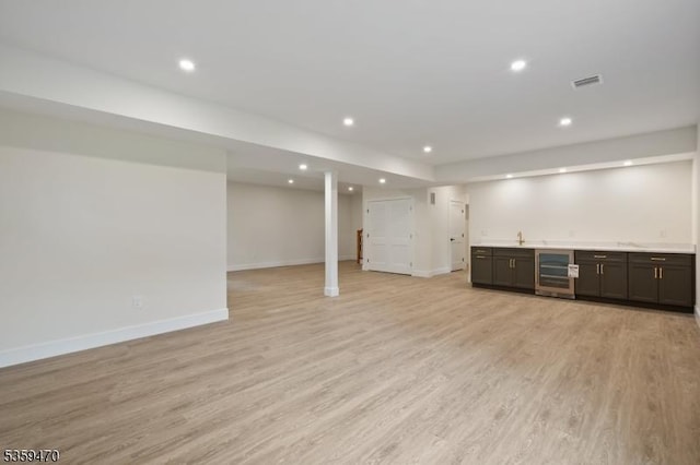 1 Willow Pl, East Hanover Twp, NJ 07936 - finished below grade area featuring beverage cooler, bar with sink, light wood-style flooring, recessed lighting, and baseboards
