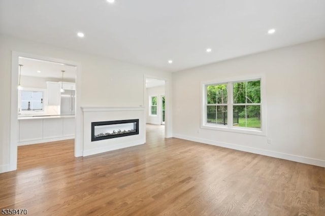 1 Willow Pl, East Hanover Twp, NJ 07936 - unfurnished living room with light wood-style floors, a glass covered fireplace, recessed lighting, and baseboards