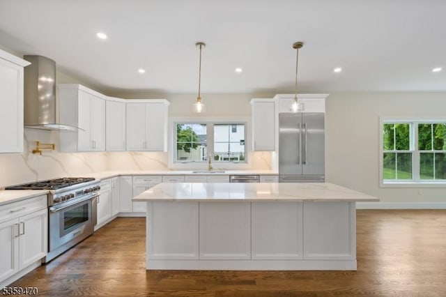 1 Willow Pl, East Hanover Twp, NJ 07936 - kitchen featuring premium appliances, wall chimney range hood, a center island, tasteful backsplash, and white cabinetry