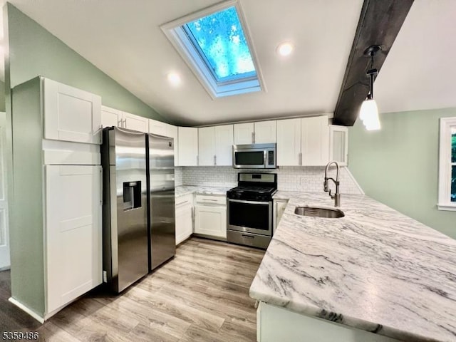 90 Georgia Ave, Jefferson Twp, NJ 07849 - kitchen featuring stainless steel appliances, a sink, a skylight, a peninsula, and light stone counters