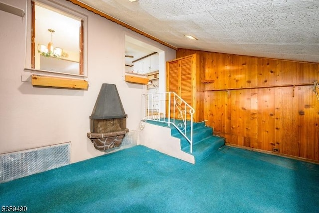777 W Scott Ave, Rahway City, NJ 07065 - staircase featuring vaulted ceiling, carpet, a wood stove, and wooden walls