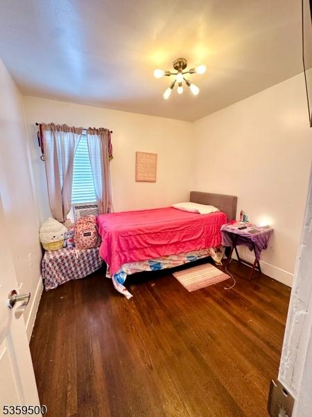 341 S 18th St, Newark City, NJ 07103 - bedroom featuring wood finished floors, baseboards, and a chandelier
