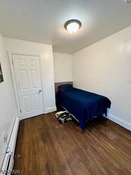 341 S 18th St, Newark City, NJ 07103 - bedroom with a baseboard heating unit, wood finished floors, and baseboards
