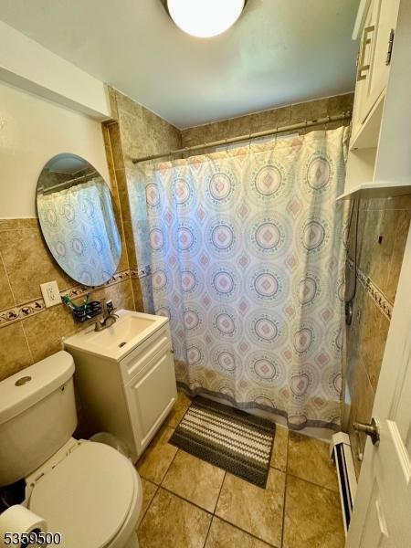 341 S 18th St, Newark City, NJ 07103 - full bath with toilet, baseboard heating, tile walls, vanity, and a shower with shower curtain