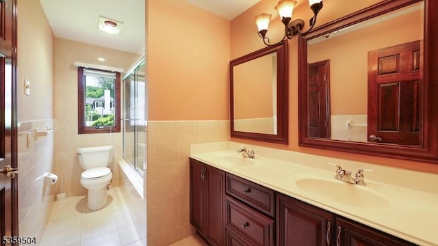 700 Schoolhouse Ln, Bound Brook Boro, NJ 08805 - bathroom with double vanity, toilet, bath / shower combo with glass door, tile patterned flooring, and tile walls