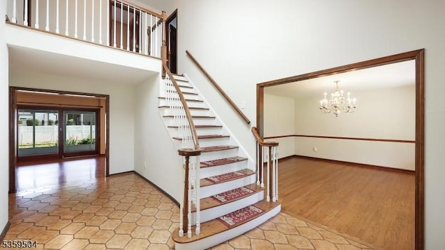 700 Schoolhouse Ln, Bound Brook Boro, NJ 08805 - staircase featuring a chandelier, a towering ceiling, and baseboards