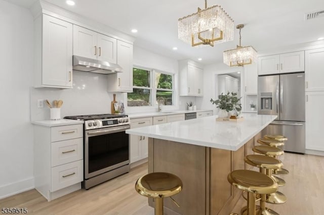 17 Misty Mountain Rd, Randolph Twp, NJ 07869 - kitchen featuring appliances with stainless steel finishes, under cabinet range hood, a chandelier, a breakfast bar area, and a sink