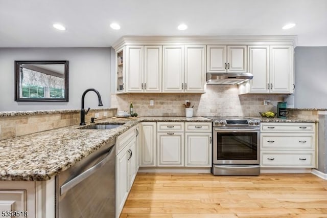 2406 Jamestown Cmn, Hillsborough Twp, NJ 08844 - kitchen featuring appliances with stainless steel finishes, a sink, under cabinet range hood, light stone counters, and decorative backsplash