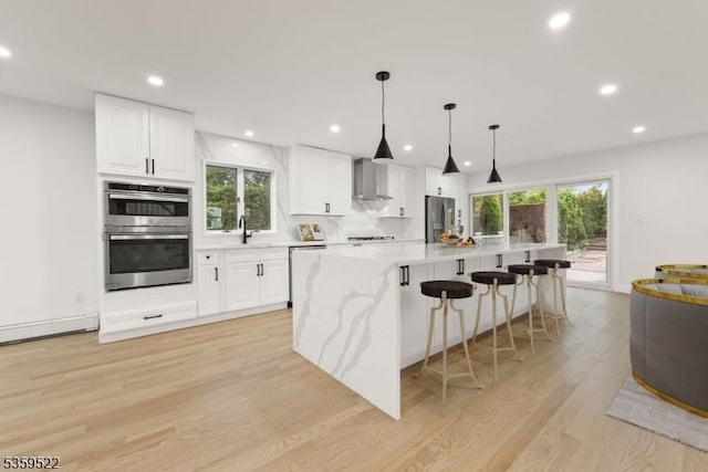 409 Washington St, Carlstadt Boro, NJ 07072 - kitchen featuring stainless steel appliances, light wood finished floors, white cabinets, wall chimney exhaust hood, and a sink