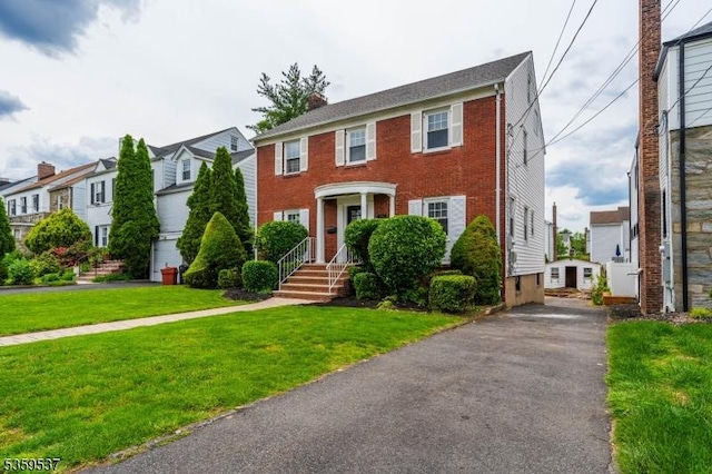 1082 Battle Hill Ter, Union Twp, NJ 07083 - colonial house featuring a front lawn, asphalt driveway, brick siding, a residential view, and a chimney
