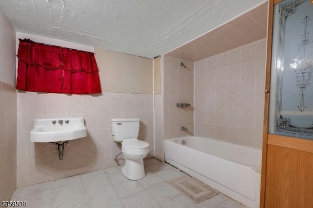 139 Pine Grove Ter, Newark City, NJ 07106 - bathroom featuring tile walls, toilet, shower / washtub combination, a sink, and a wainscoted wall