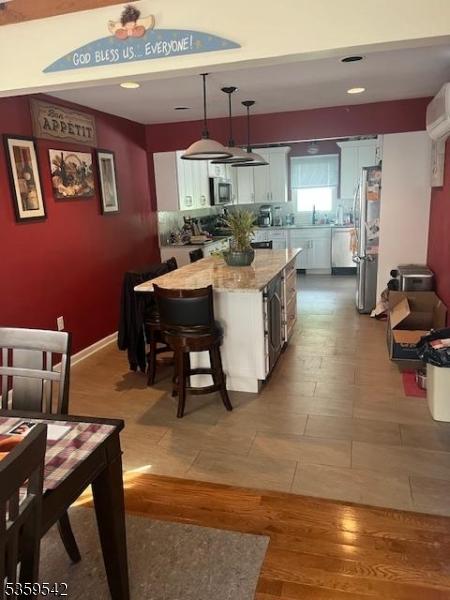 2 Erin Ln, Vernon Twp, NJ 07422 - kitchen with appliances with stainless steel finishes, an AC wall unit, a center island, decorative light fixtures, and a sink