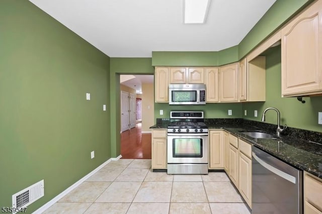 256 Marcia Way, Bridgewater Twp, NJ 08807 - kitchen with appliances with stainless steel finishes, a sink, light tile patterned flooring, dark stone counters, and baseboards
